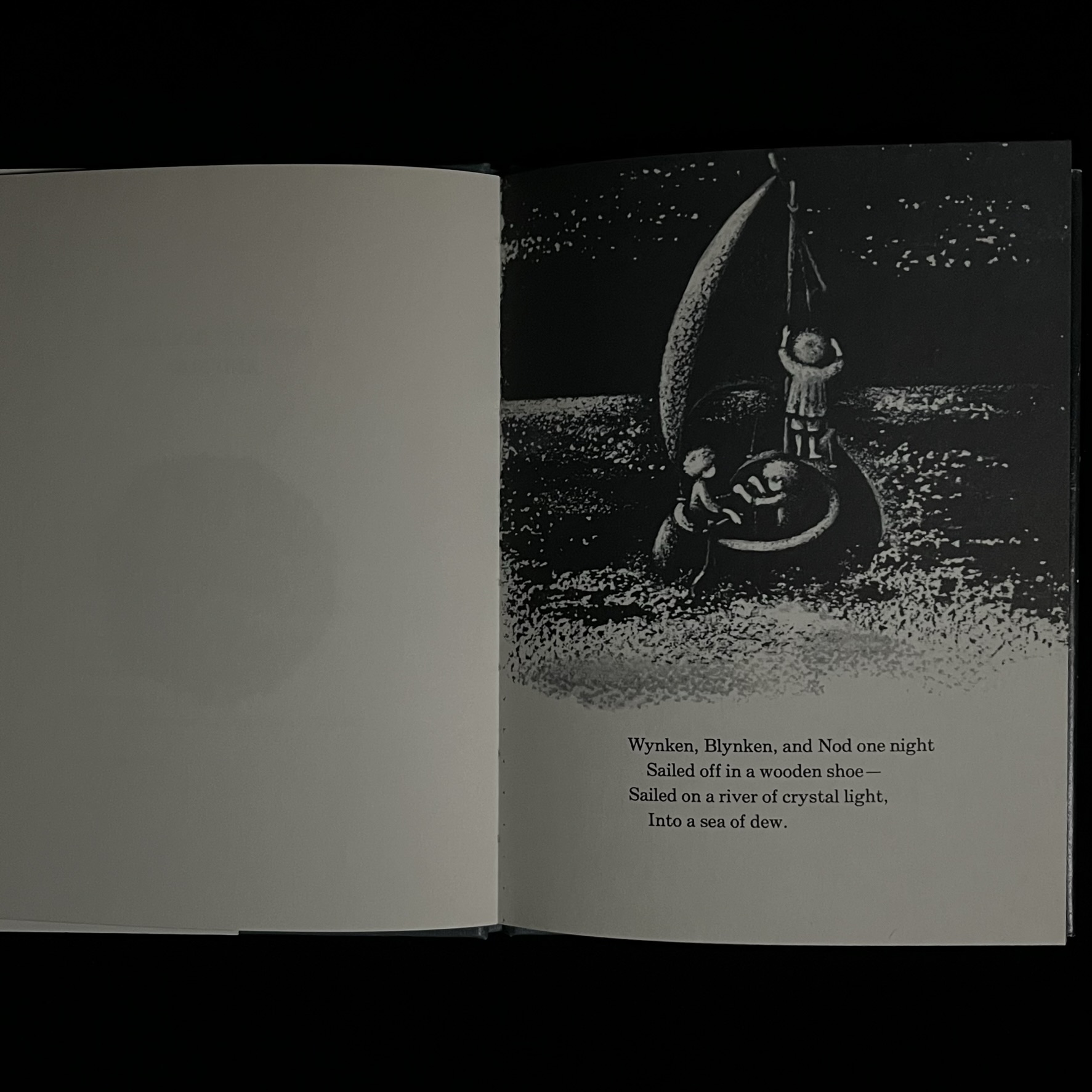 本のページの写真。３人の男の乗る木靴の舟。１人が帆をたて１人が舵をあやつっています