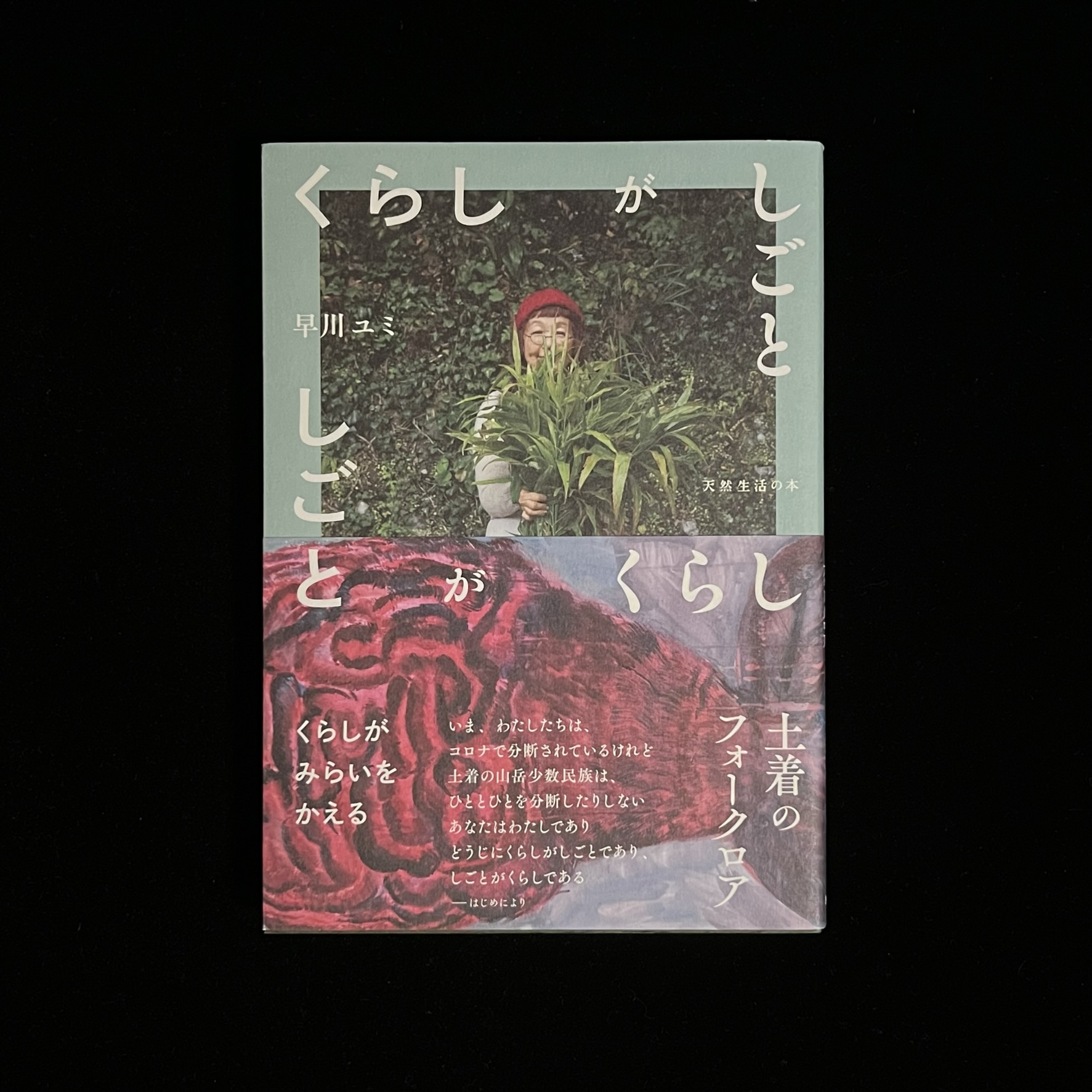 早川ユミさんの『くらしがしごと』の本の表紙の写真。早川ユミさんが収穫した新しょうがの束をかかえている写真が載っています。帯には「土着のフォークロア」や「くらしがみらいをかえる」の文字が書かれています。