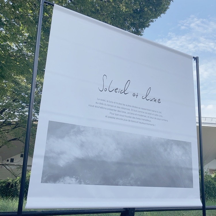 「Soleil et Lune」の本屋のバナースタンドの写真。お店のロゴに空の写真、ショップイメージの文章が書かれています。