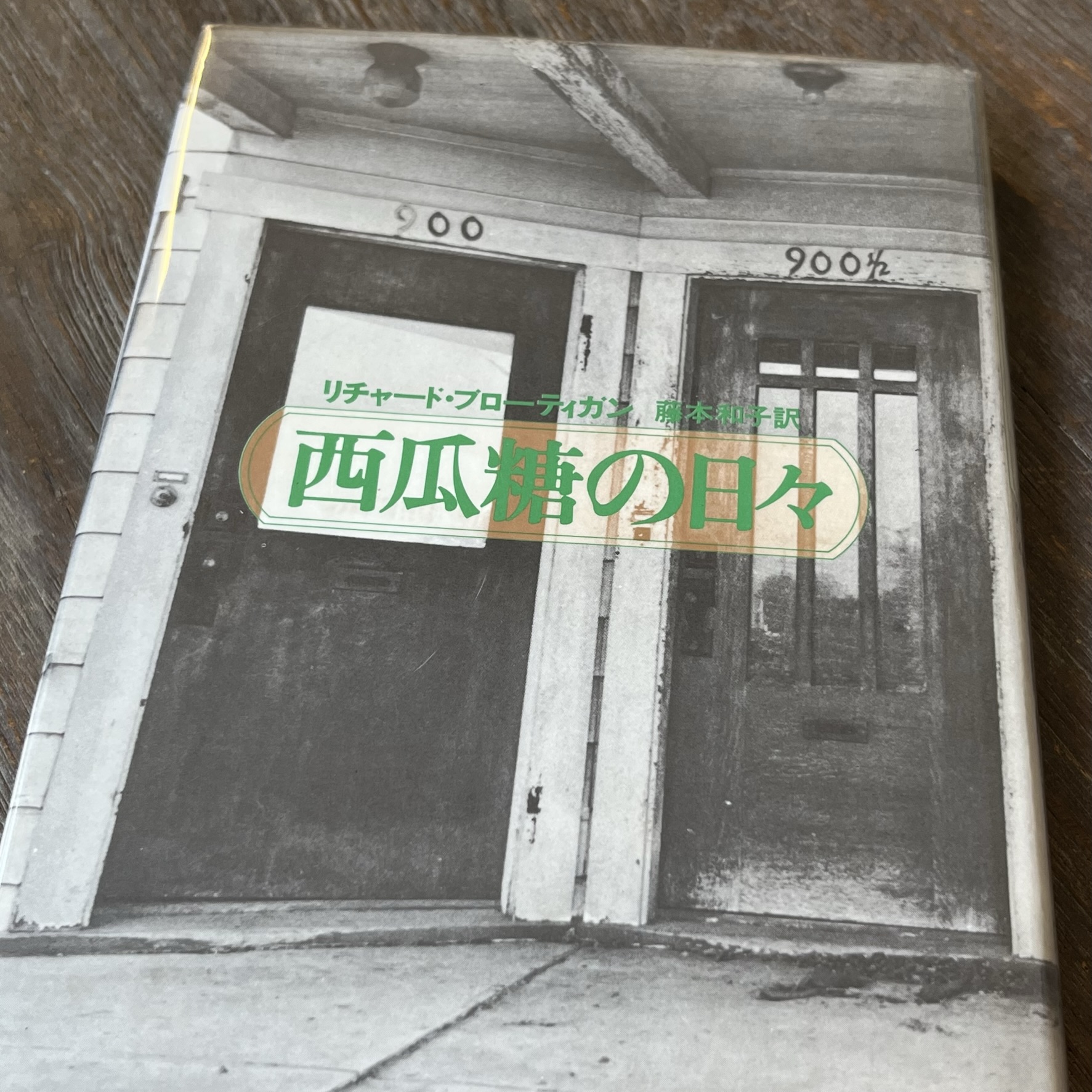 『西瓜糖の日々』の本の表紙の写真。モーテルの入口でしょうか、部屋のドアが２つ、それぞれのドアの前の天井には電灯がついています。それぞれのドアの上には「900」と「900 1/2」という文字が書かれています
