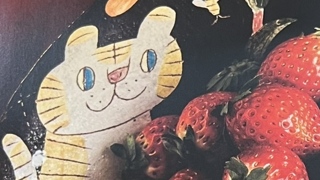 『なにのせる？』の写真集のページの写真。猫の絵柄のお皿にいちごが盛られている写真です。
