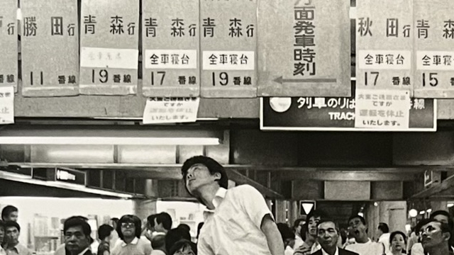 『上野駅の幕間』の本の表紙の写真です。上野駅の改札で駅員は上の行先案内板を見上げている写真です。