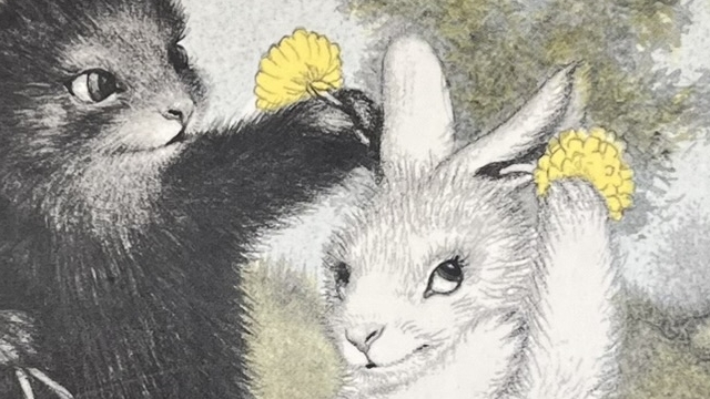 『しろいうさぎとくろいうさぎ』の絵本の表紙のイラストです。黒いうさぎが白うさぎの頭にタンポポのお花をさしている絵が描かれています。
