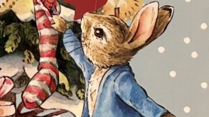 『PETER RABBIT 25の物語のアドベント』の絵本の表紙のイラストです。クリスマスツリーのそばのピーターラビットが描かれています。