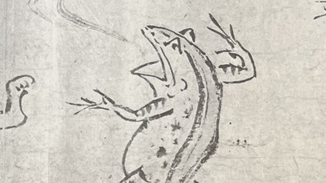 『かえるのごほうび』の絵本のページのイラストです。カエルが口を開けて気炎をあげている絵です（鳥獣戯画の絵）。