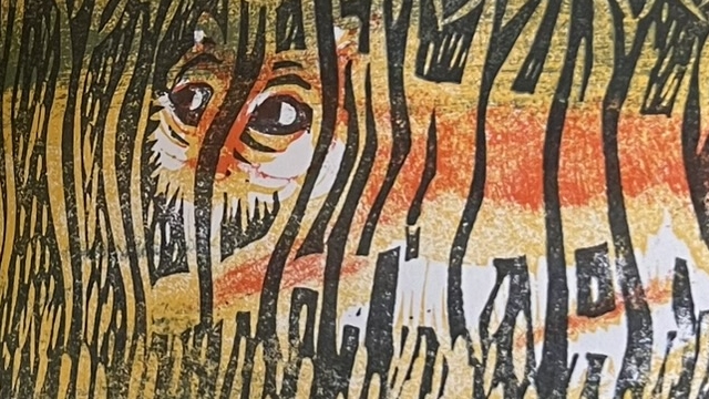 『あおいやまいぬ』の絵本のページのイラストです。草むらの中にまぎれているトラが描かれています。