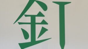 『漢字の感字』の本のページのイラストです。「針」感じの作りの十字の部分が「くぎ」の絵になっています。
