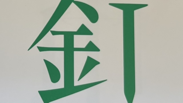 『漢字の感字』の本のページのイラストです。「針」感じの作りの十字の部分が「くぎ」の絵になっています。