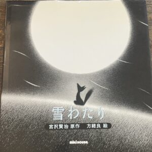 『雪わたり』の絵本の表紙です。雪の上できつねが満月を見上げている絵が描かれています。
