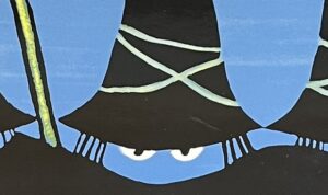 『すてきな三にんぐみ』の絵本の表紙です。黒い帽子をかぶった三にんぐみの男の顔が描かれています。